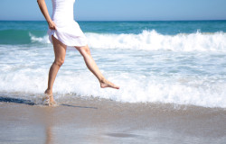 Female leg walking on the beach in the ocean