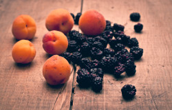 Fresh apricots and blackberries on wooden background